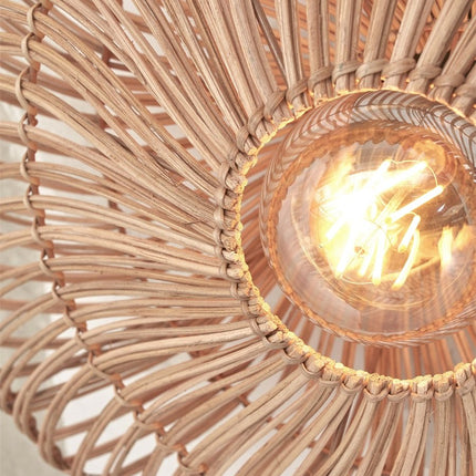 Close-up of the natural rattan weave and the central bulb of the lit Zanzibar wall light