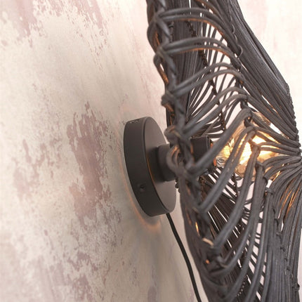 Side view of the black metal wall bracket of the Zanzibar wall light with textile cable and bulb on