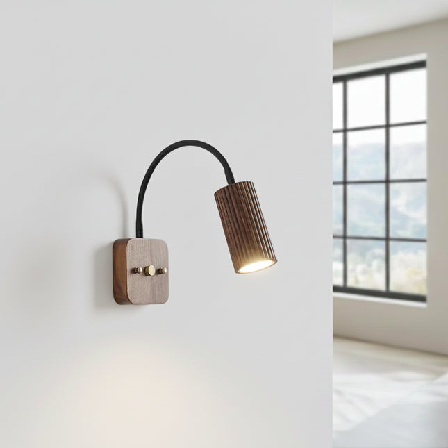 Applique en bois de noyer allumée diffusant une lumière chaude le long du mur