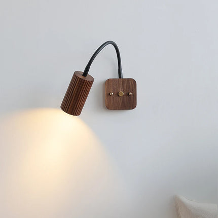 Applique en noyer projetant un faisceau chaud orientable sur un mur clair