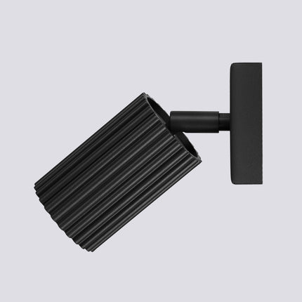 Gros plan sur la tête cylindrique striée noire de l'applique Oslo et son ouverture pour ampoule GU10