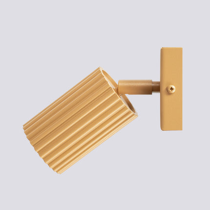 Gros plan sur la tête cylindrique striée dorée de l'applique Oslo et son ouverture pour ampoule GU10