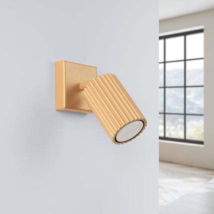 Applique murale orientable Oslo dorée vue de face, tête striée en aluminium et plaque de fixation carrée