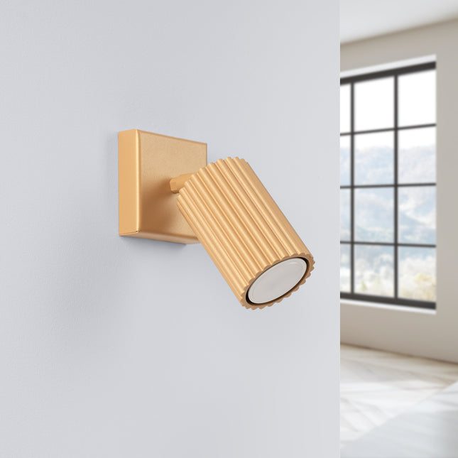 Applique murale orientable Oslo dorée vue de face, tête striée en aluminium et plaque de fixation carrée