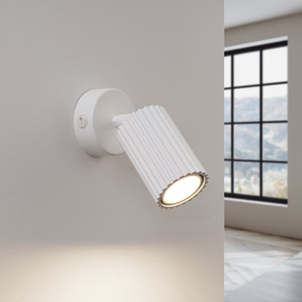 Applique murale Oslo blanche allumée diffusant une lumière chaude dirigée sur le mur