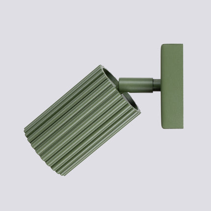 Gros plan sur la tête cylindrique striée vert olive de l'applique Oslo et son ouverture pour ampoule GU10