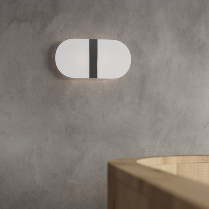 Vue rapprochée du diffuseur en verre blanc de l'applique, lumière homogène et douce.