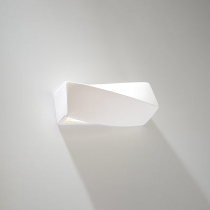 Applique murale Petit Sigma en céramique blanche allumée dans un salon contemporain