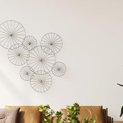 Appliques circulaires à rayons noires groupées au-dessus d'un canapé en cuir