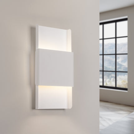 Applique murale blanche installée sur un mur beige, éclairage chaleureux dans une chambre
