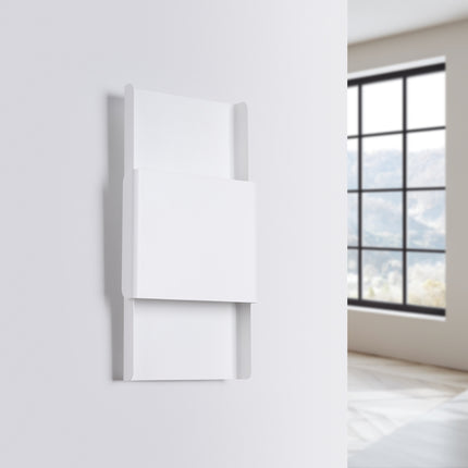 Applique murale design blanche fixée sur un mur clair, vue de biais, ambiance lumineuse douce