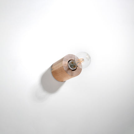 Applique cylindre en bois naturel fixée au mur blanc, ampoule filament E27 à l'horizontale apparente.