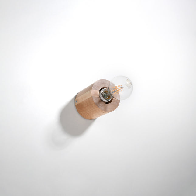 Applique cylindre en bois naturel fixée au mur blanc, ampoule filament E27 à l'horizontale apparente.