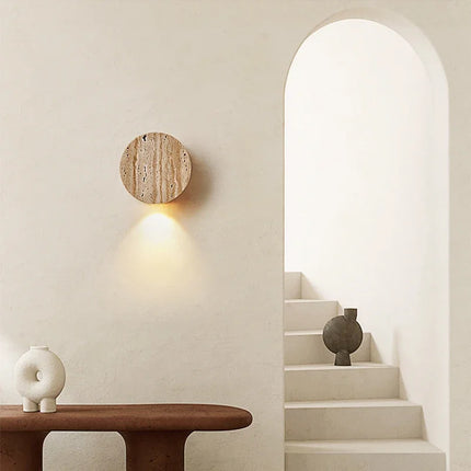 Applique ronde en travertin diffusant une lumière chaude