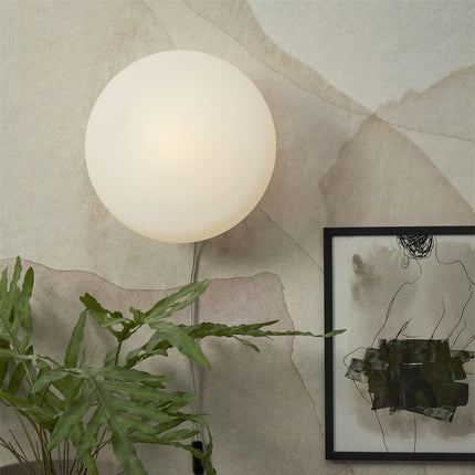 Applique murale Sapporo 34 cm sur un mur, globe en verre blanc opalin allumé