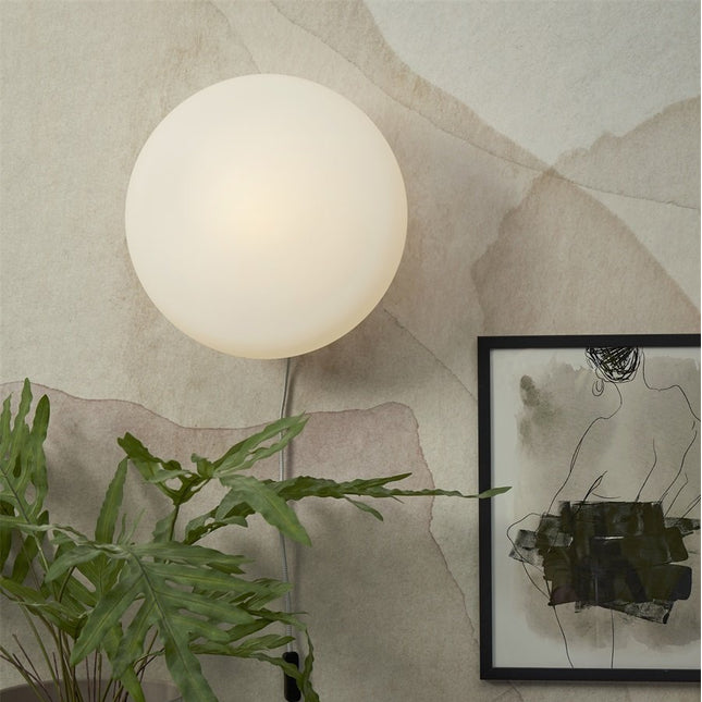 Applique murale Sapporo 34 cm sur un mur, globe en verre blanc opalin allumé