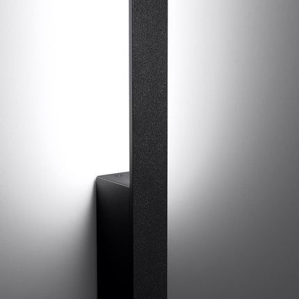 Applique murale noir Slim Design allumée vue en angle, ligne lumineuse verticale