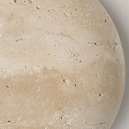 Détail de la texture veinée et piquetée du travertin naturel de l'applique murale
