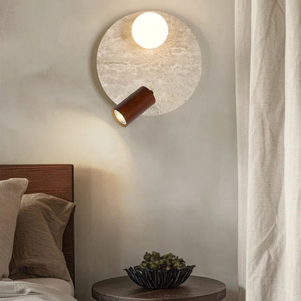 Applique en travertin avec globe en verre et projecteur en bois au chevet d'un lit