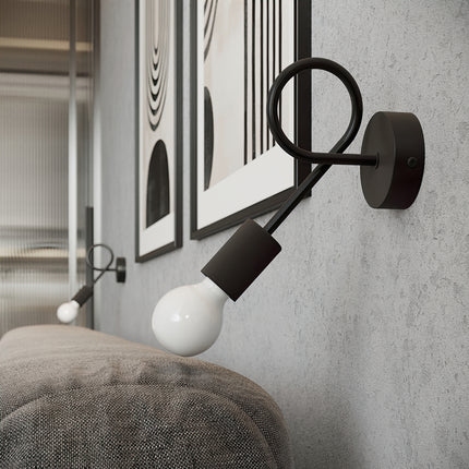 Applique Twist Moderne noire allumée près d'un cadre graphique dans une chambre