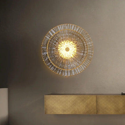 Applique en verre strié doré éclairée au-dessus d'un meuble laiton dans un salon feutré