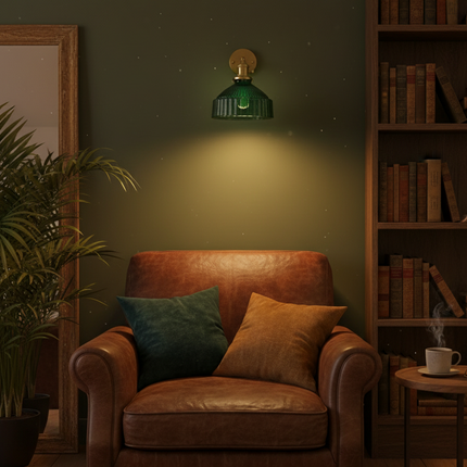 Applique en verre vert strié allumée au-dessus d'un fauteuil en cuir dans un coin lecture tamisé