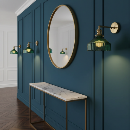 Trois appliques en verre vert et laiton alignées sur un mur bleu canard dans une entrée