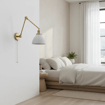 Applique vintage en laiton et céramique installée en tête de lit dans une chambre nordique