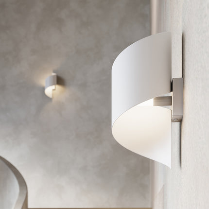 Gros plan sur l'applique Vortex acier blanc allumée, diffuseur intérieur blanc opalin