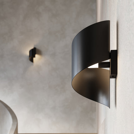 Gros plan sur l'applique Vortex acier noir allumée, diffuseur intérieur blanc opalin