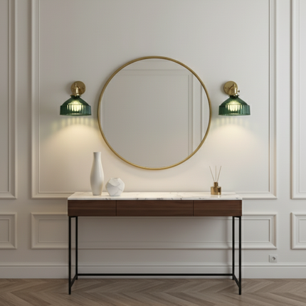 Deux appliques en verre strié vert et laiton de part et d'autre d'un miroir rond au-dessus d'une console
