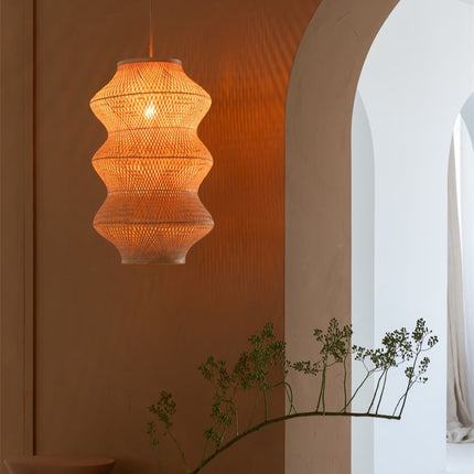 Gros plan sur une ampoule à filament nichée dans le tressage fin de bambou naturel, lumière chaude et enveloppante.