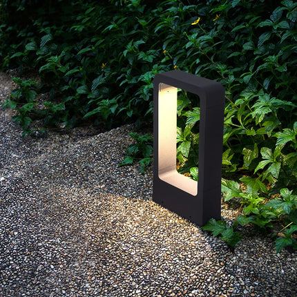 Borne de jardin LED anthracite 30 cm posée près d'un massif végétal sur une allée gravillonnée