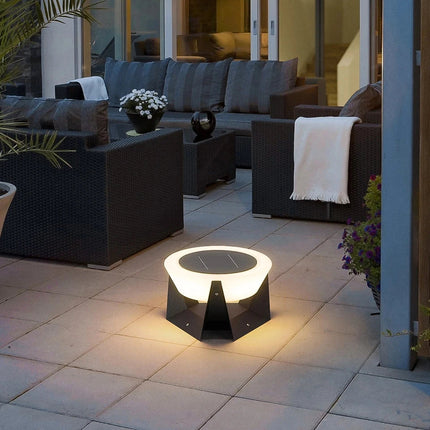 Borne solaire allumée sur une terrasse aménagée avec un salon en résine tressée