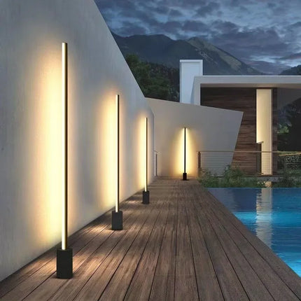 Bornes extérieures LED noires alignées le long d'une terrasse au bord d'une piscine