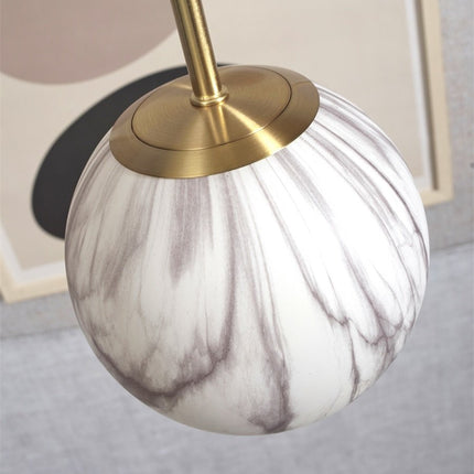 Détail de la fixation en laiton doré entre la tige et le globe en verre effet marbre