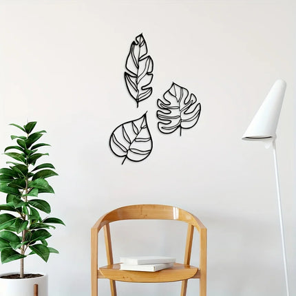 Trois feuilles décoratives en métal noir au-dessus d'une chaise en bois et d'un lampadaire blanc