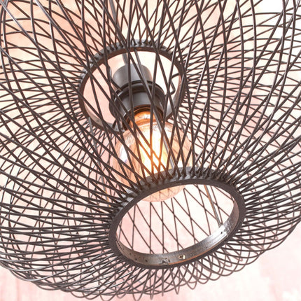 Gros plan sur les fils de métal noir tressés de l'abat-jour du lampadaire Cango avec ampoule allumée