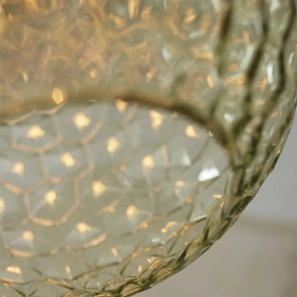 Gros plan sur la texture nid d'abeilles du verre soufflé vert de la suspension Venice