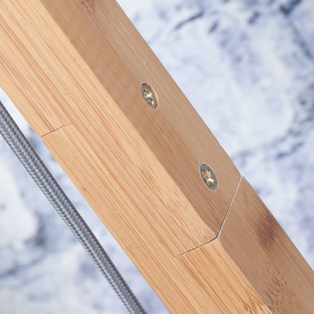 Gros plan sur la jonction du bras en bambou massif du lampadaire Andes, finition bois naturel