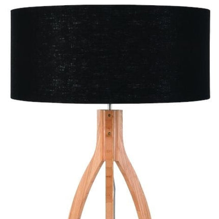 Abat-jour cylindrique en lin noir texturé du lampadaire Annapurna, posé sur son piètement en bambou naturel