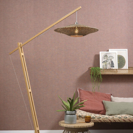 Lampadaire Bali bambou tressé allumé, éclairage tamisé au-dessus d'un canapé