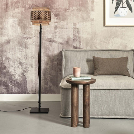 Lampadaire Bhutan bambou tressé noir et naturel posé près d'un canapé gris et d'une table basse en bois