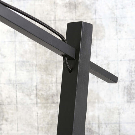 Câble textile noir suspendant l'abat-jour en bambou tressé à la potence métallique du lampadaire