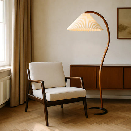 Lampadaire nordique en bois courbé à côté d'un fauteuil clair et d'une enfilade en bois