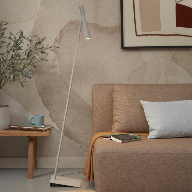Lampadaire Bordeaux en fer gris clair pres d'un canape dans un salon japandi