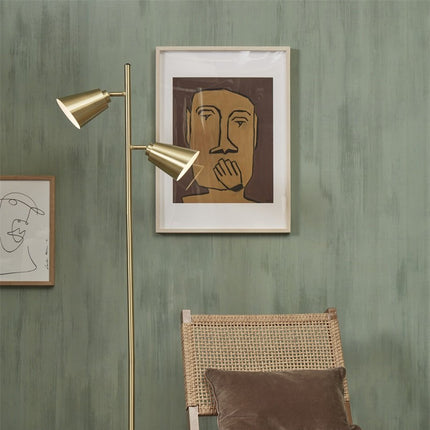 Lampadaire Bremen doré devant un cadre illustre, ambiance salon