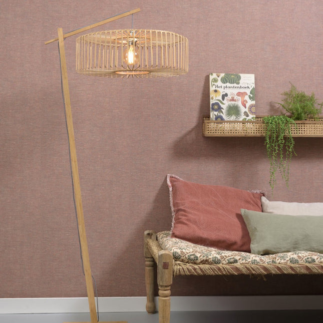 Lampadaire Bromo bambou naturel, abat-jour cage tressée allumé dans un salon aux teintes roses et bohèmes