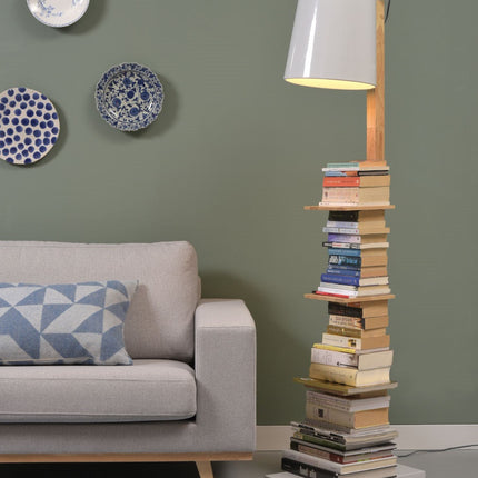 Lampadaire Cambridge bois et fer blanc allumé dans un salon aux murs vert sauge, à côté d'un canapé gris clair