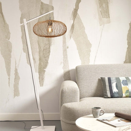 Lampadaire Cango pied bois blanc et abat-jour bambou tressé, dans un salon près d'un canapé beige